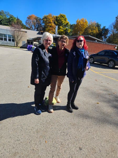 Anna Hopkins with two supporters outside a Ward 9 school on a sunny autumn day