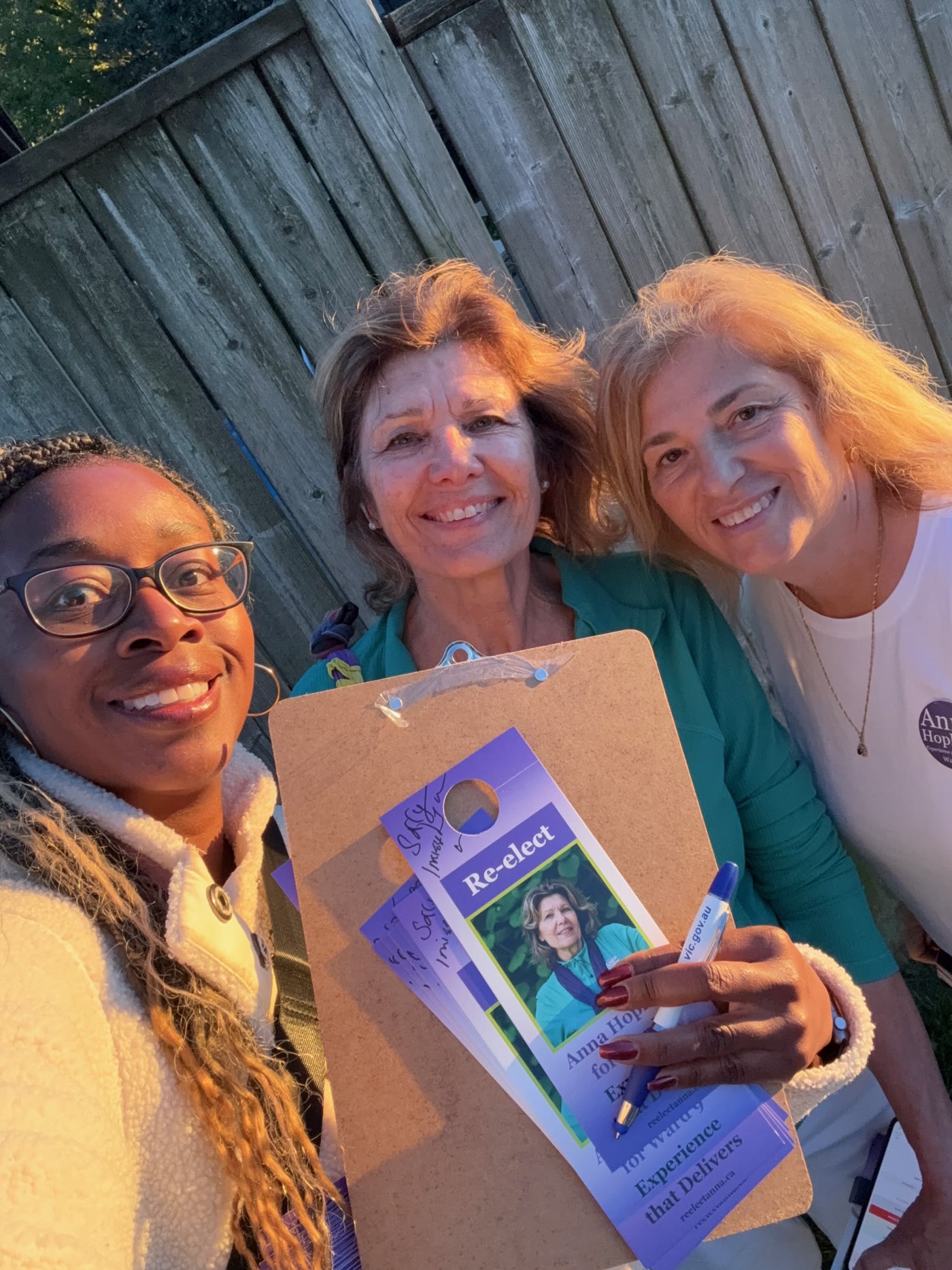 Anna Hopkins with supporters holding Re-elect Anna Hopkins campaign literature