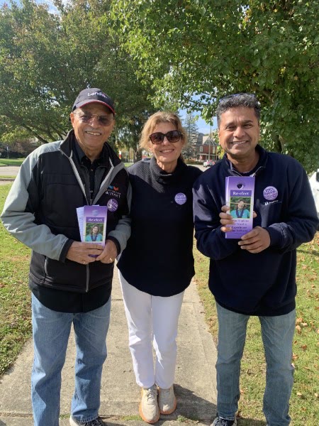 Anna Hopkins with two volunteers holding campaign literature while canvassing a Ward 9 street